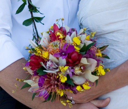 This photograph shows a vibrant tropical wedding bouquet