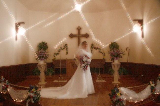 Surrounded by lavish wedding flowers and decorations this charming bride