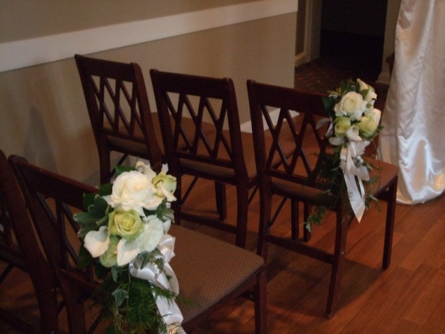 These white and pale green rose aisle markers give this semiformal wedding 