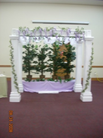 This particular wedding ceremony features an arbor decorated with purple 