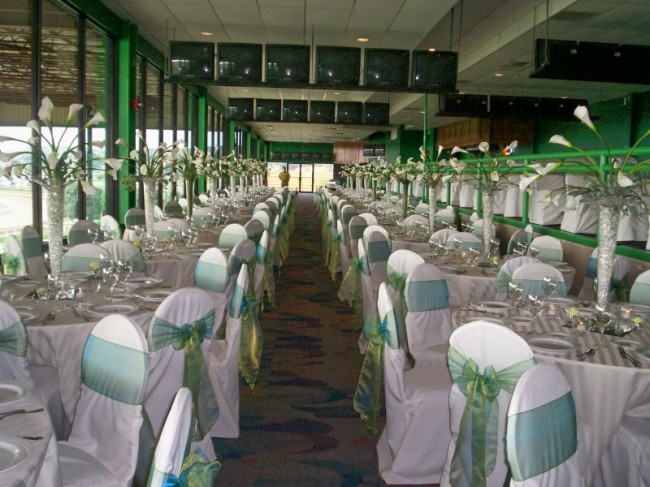 Wedding reception in a green theme Pilsner vases filled with calla lilies 