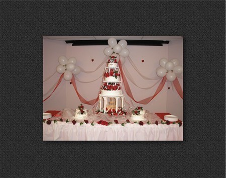 adorning the three tier fountain wedding cake with romantic red roses