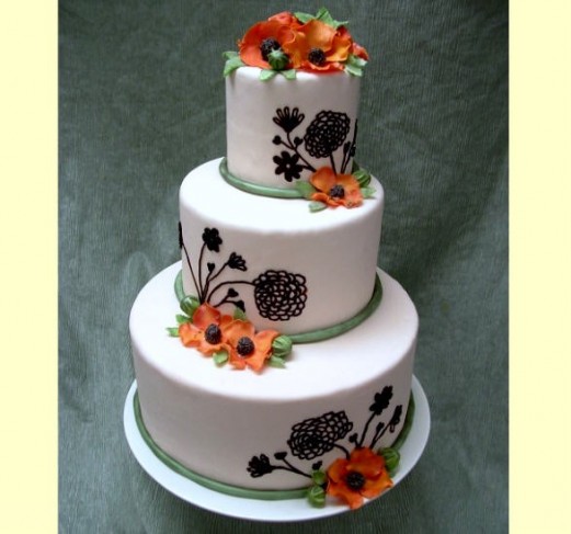 Orange Chinese poppies accent floral icing designs on a fondant wedding cake