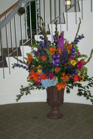A large urn full of summer flowers greeted the wedding guests as they came 