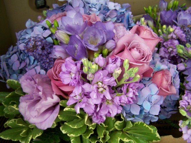 Bouquet of lavender and purple blooms in a nosegay style bridal bouquet is