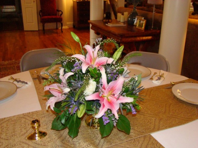 Round centerpiece of pink oriental lilies and mixed flowers for a 