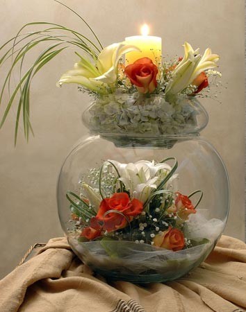 This wedding centerpiece features an open spherical glass vase with a 