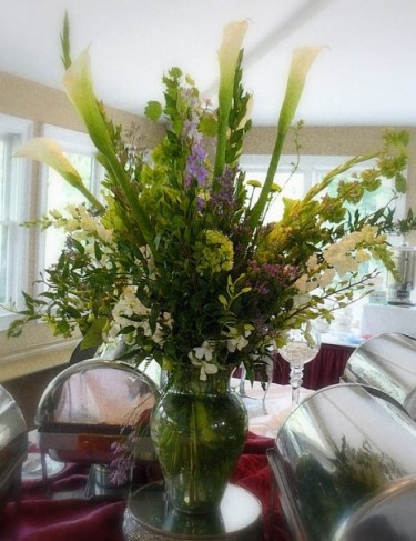 This wedding reception photo shows a lovely buffet table centerpiece adding