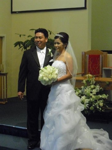 This gorgeous bride carries a wedding bouquet made of classic white roses 