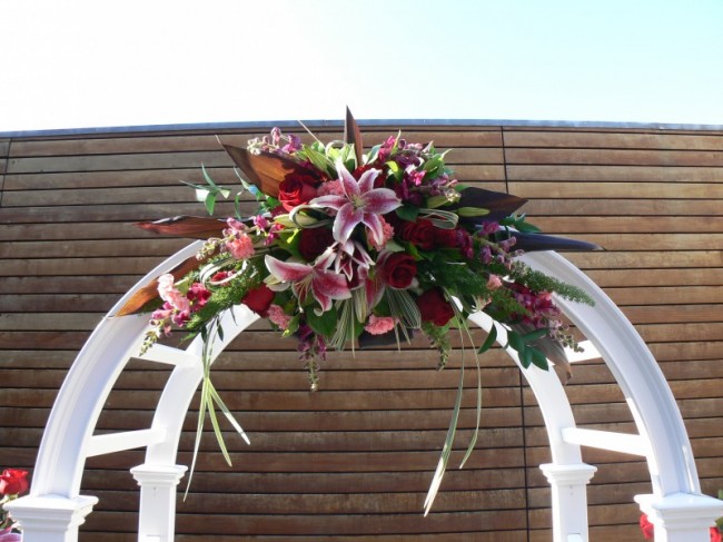 Lilies and red roses make this wedding archway picture perfect
