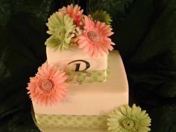 Here is a two tier wedding cake in shades of pink green and white