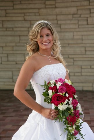 She holds a beautiful cascading bridal bouquet made from stephanotis 