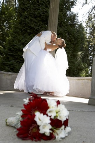 lays on the ground at their feet in this elegant wedding portrait