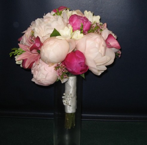 A beautiful pink wedding bouquet is created with a variety of gorgeous 