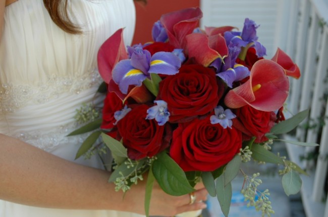 This red and purple bridal bouquet is created with red calla lilies blue 