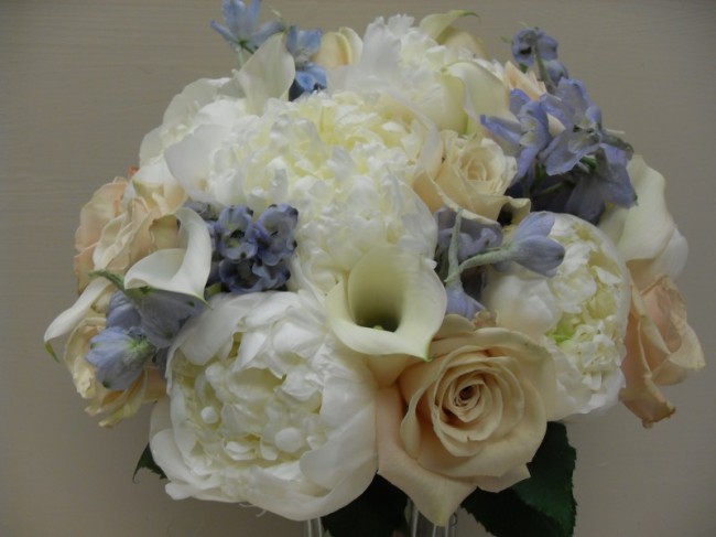 This is an elegant bridal bouquet created with ivory roses white peonies 