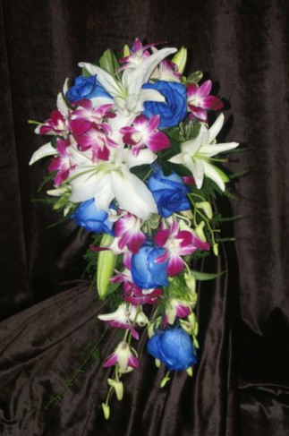 This tropical cascading wedding bouquet is filled with purple orchids blue