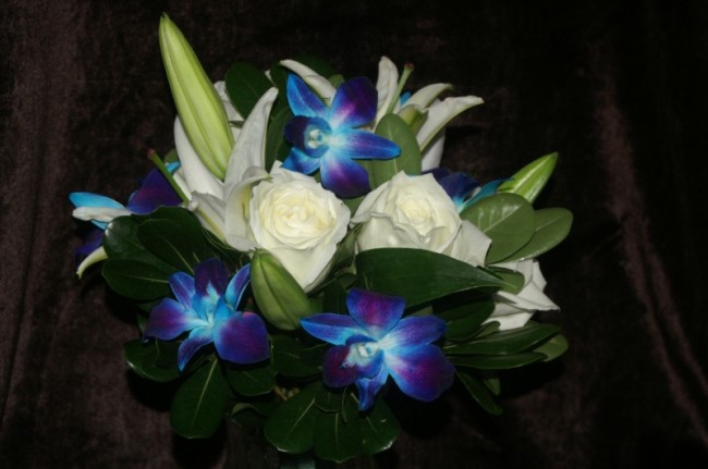 This stunning wedding bouquet is filled with blue orchids white lilies and