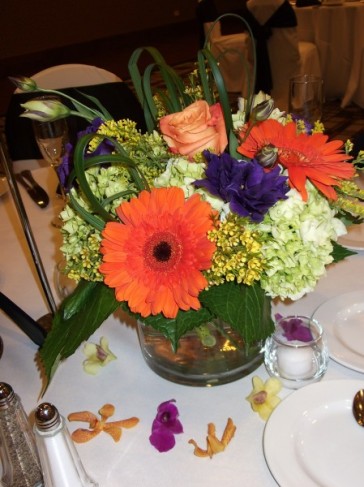 Made from orange gerbera daisies green hydrangea purple lisianthus 