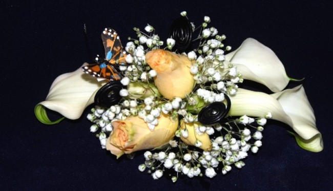 White calla lilies and peach roses make up this beautiful prom corsage