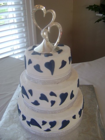 This three tier white wedding cake is all about love With navy blue fondont