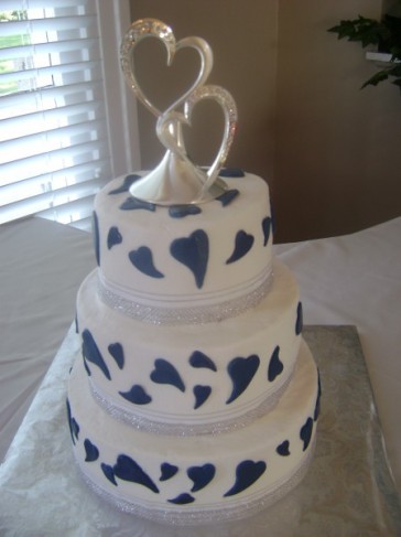 This three tier white wedding cake is all about love With navy blue fondont 