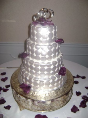 This beautiful four tier white wedding cake has been decorated with silver
