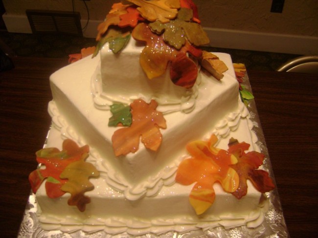 Fall is the theme for this three their white wedding cake