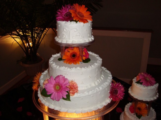 This cake has been accented with hot pink and orange gerbera daisies along