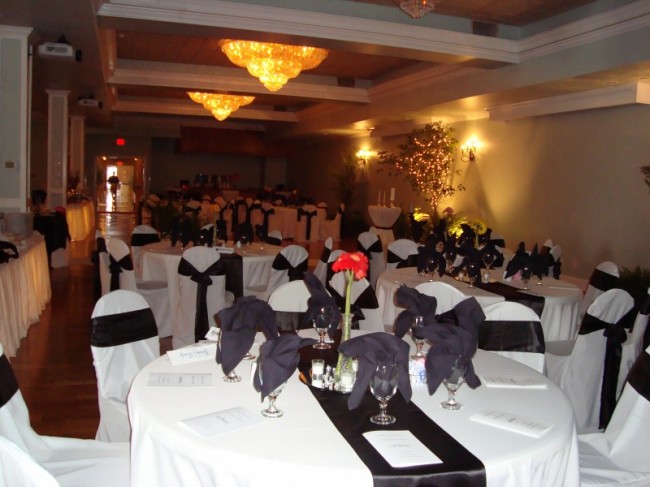 Simple bud vases have been placed on each table containing red daisies