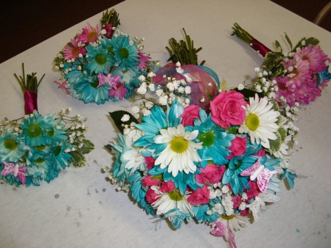 Pink and teal ribbon decorates the stems of the bridal bouquet creating a
