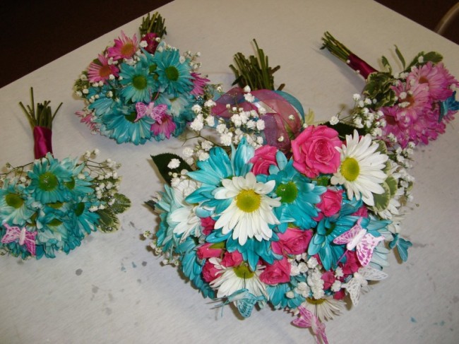 Pink and teal ribbon decorates the stems of the bridal bouquet creating a 