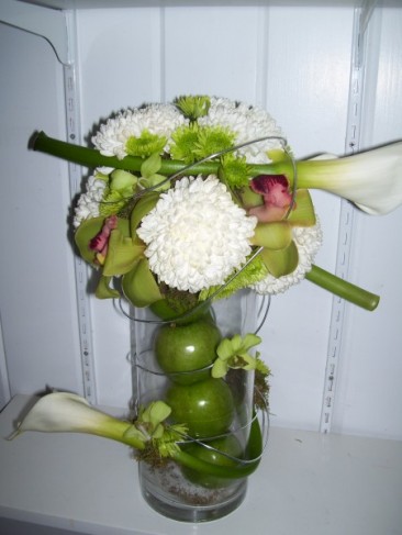 This beautiful wedding reception centerpiece is filled with green apples 