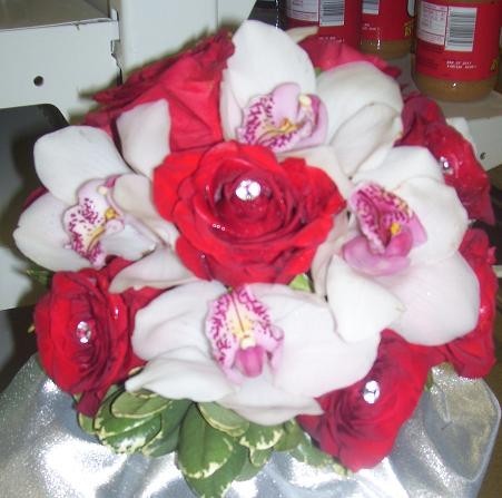 This bridal bouquet has been created from red roses and cymbidium orchids