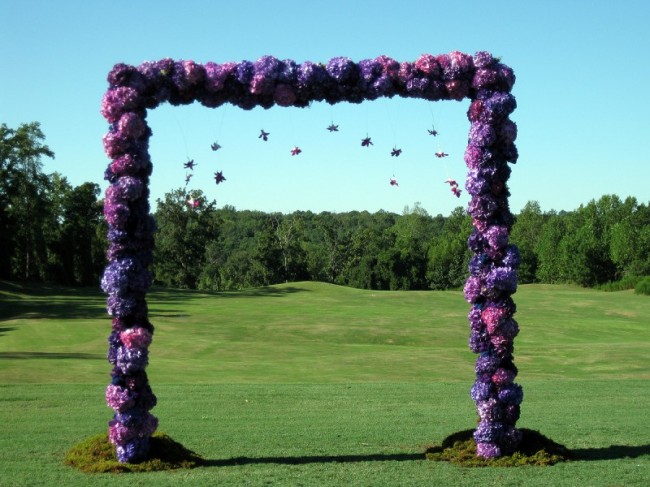 Gorgeous purple wedding flowers in variety of colors make this arch simply 