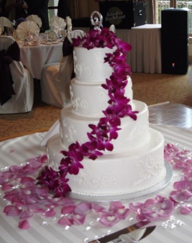 Beautiful fuchsia wedding flowers adorn this beautiful 4 tired wedding cake