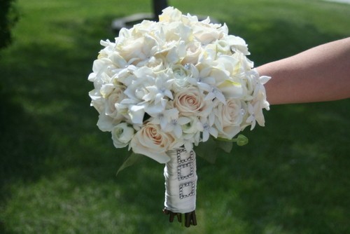 This white bridal bouquet features gorgeous white flowers and is wrapped 