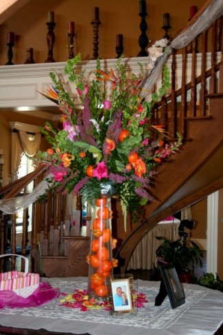 This colorful wedding reception centerpiece shows off bright orange and pink