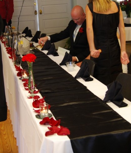 This wedding table arrangement features beautiful red wedding flowers and