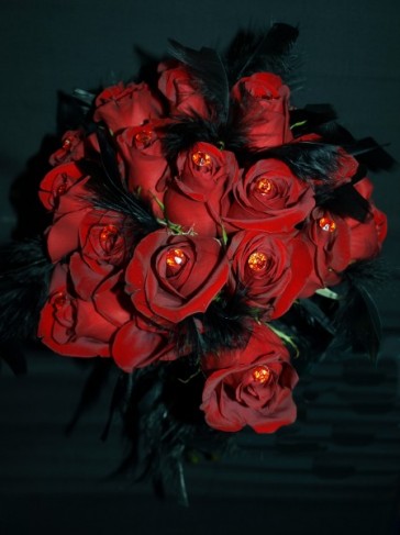 This beautiful red rose wedding bouquet features black feathers as accents