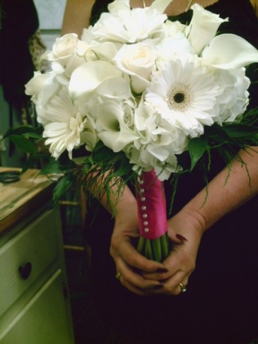 This white wedding bouquet features beautiful calla lilies daisies and is