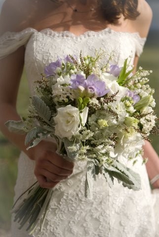 This bride is carrying a lovely cream wedding bouquet with hints of purple 