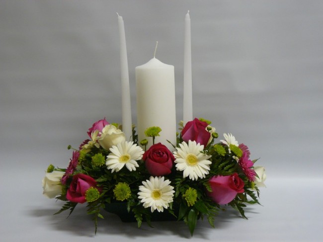 This unity candle features beautiful wedding flowers around the bottom of 