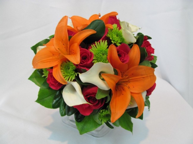 This colorful bridal bouquet features hot pink roses orange lilies white 