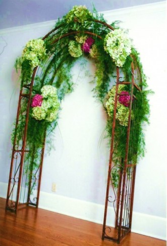 This beautiful wedding arch features green and pink wedding flowers