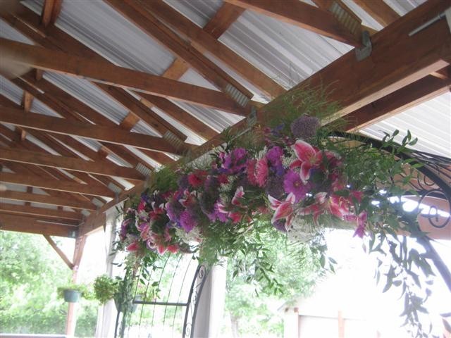 This beautiful wedding arch adorns gorgeous purple and pink wedding flowers