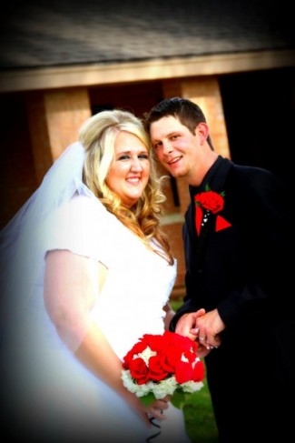 Bride and Groom With Red Wedding Flowers Share