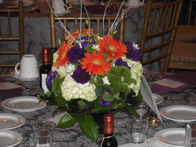 wedding reception centerpiece filled with gorgeous orange purple and