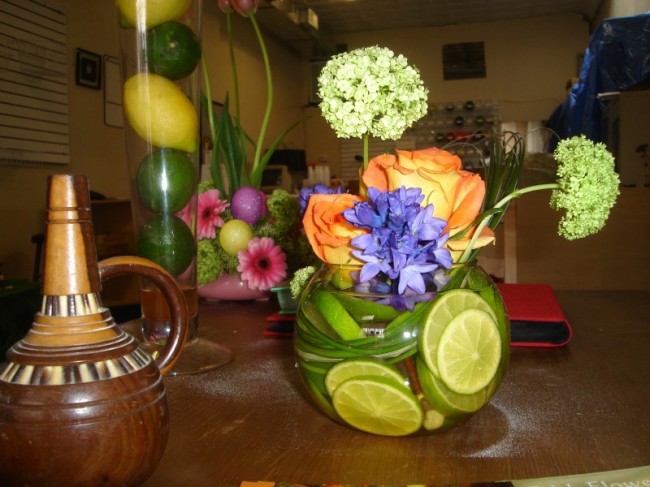 It features colorful flowers and is accented with limes wedding centerpieces