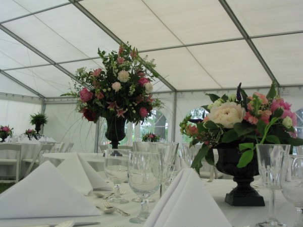A beautiful wedding reception held in a tent that is decorated with table 